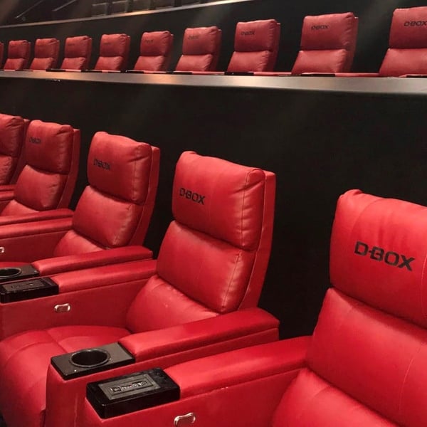 Des fauteuils inclinables haptiques D-BOX rouges dans un cinéma