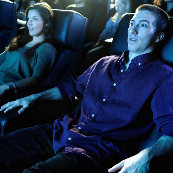 A woman and a man are seated in a movie theater
