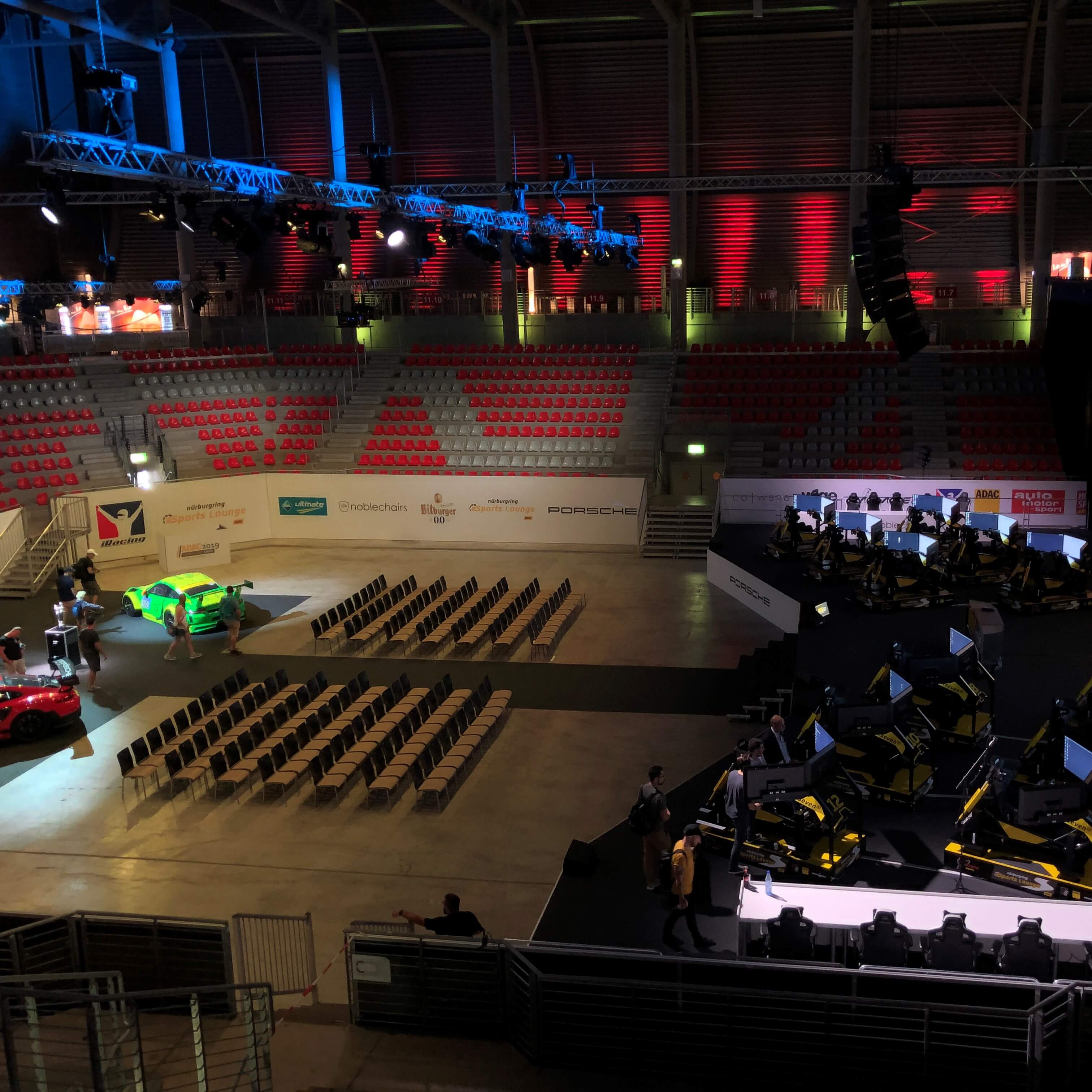 A sim racing event is set up in an empty auditorium