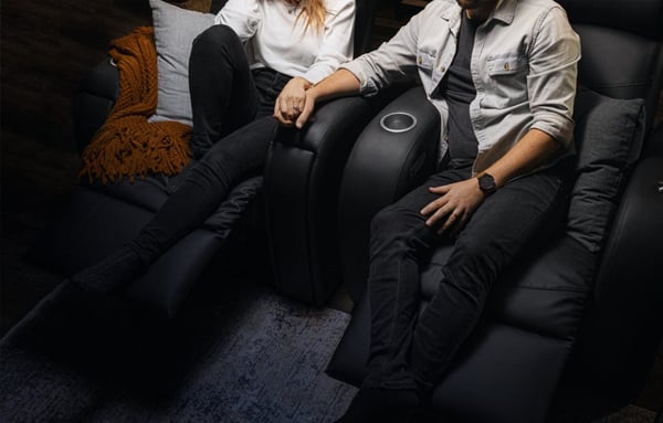 Un couple assis dans des sièges de cinéma maison D-BOX