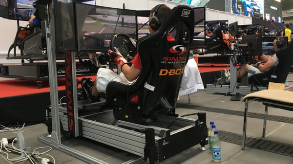 A man races on a D-BOX sim racing simulator