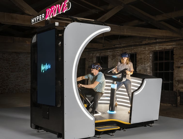 Deux personnes profitant d'une attraction haptique immersive de type D-BOX.