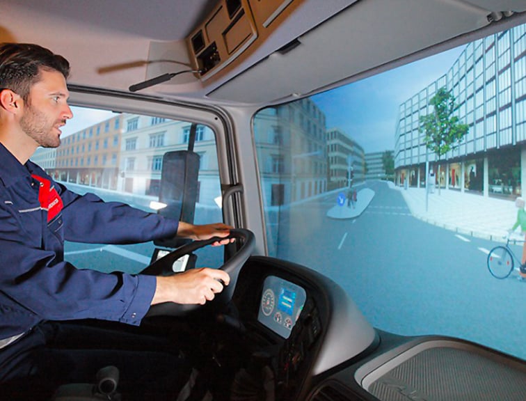 Un homme qui conduit un simulateur de camion haptique