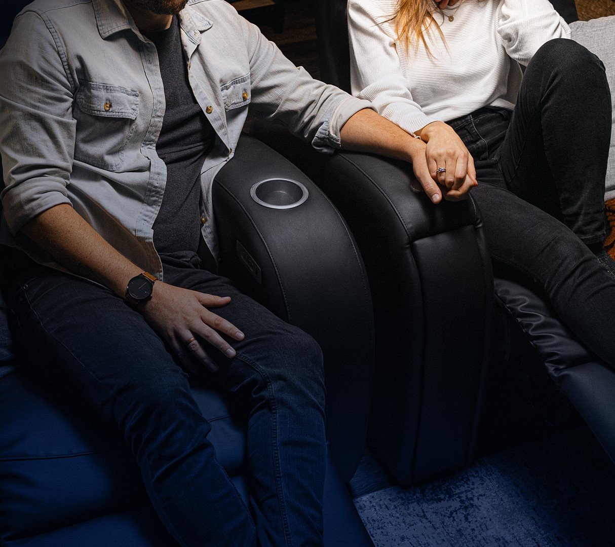Un couple se tenant la main dans des fauteuils haptiques D-BOX